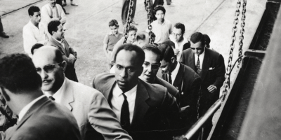 Frantz Fanon marchant sur une passerelle de navire. À la droite de Fanon se trouve Rheda Malek, un journaliste du journal du Front de libération nationale algérien El Moudjahid. Frantz Fanon Archives / IMEC