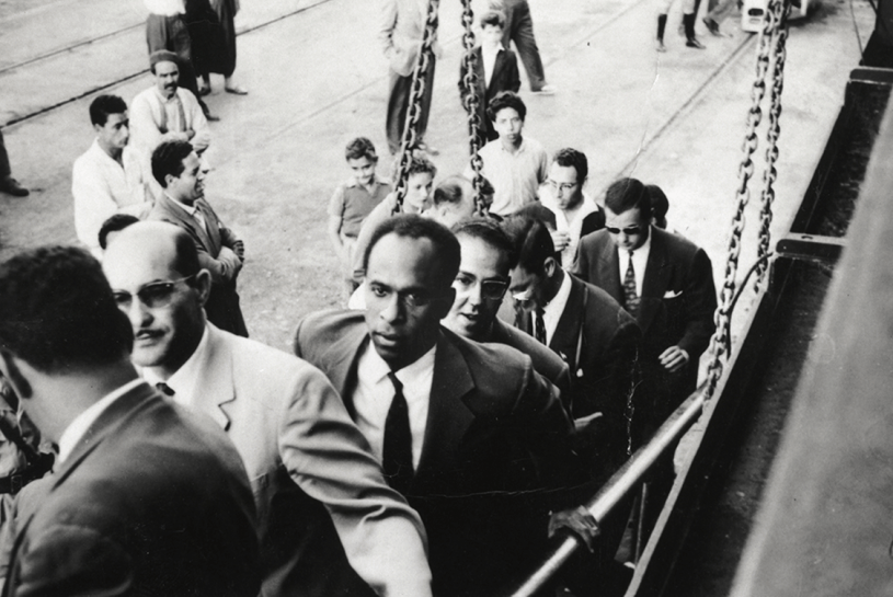 Frantz Fanon marchant sur une passerelle de navire. À la droite de Fanon se trouve Rheda Malek, un journaliste du journal du Front de libération nationale algérien El Moudjahid. Frantz Fanon Archives / IMEC